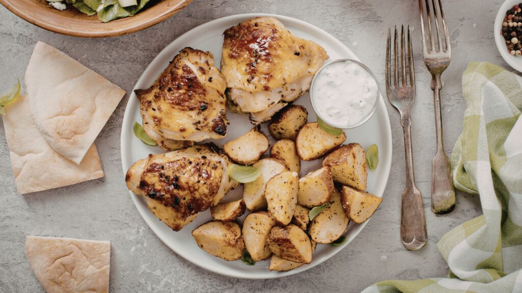 Flat lay shot of a plate of chicken and potatoes.