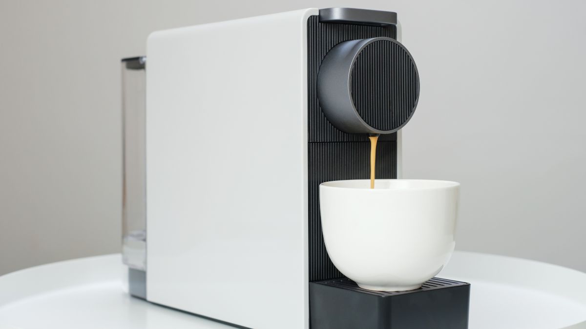 Coffee dripping down a white coffee cup from a K-cup Coffee Machine.