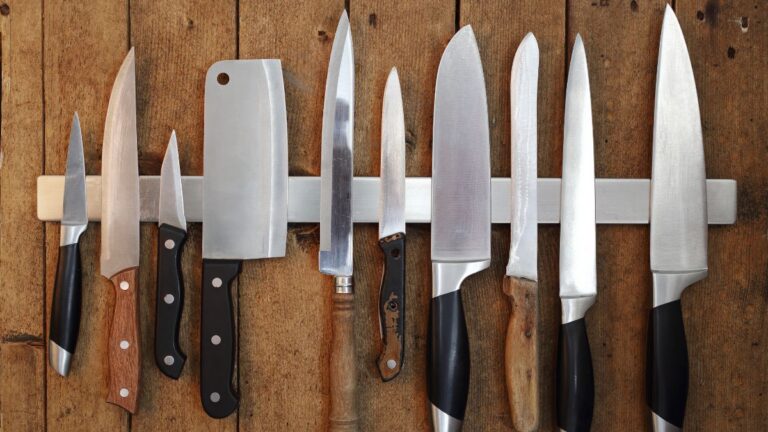 Flat lay shot of a row of kitchen knives on a magnetic rack.