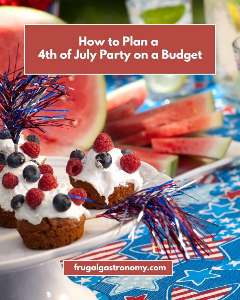 A 4th of July table scape with themed cupcakes on a white cupcake stand, sliced watermelons on a platter behind, and glasses of drinks behind.