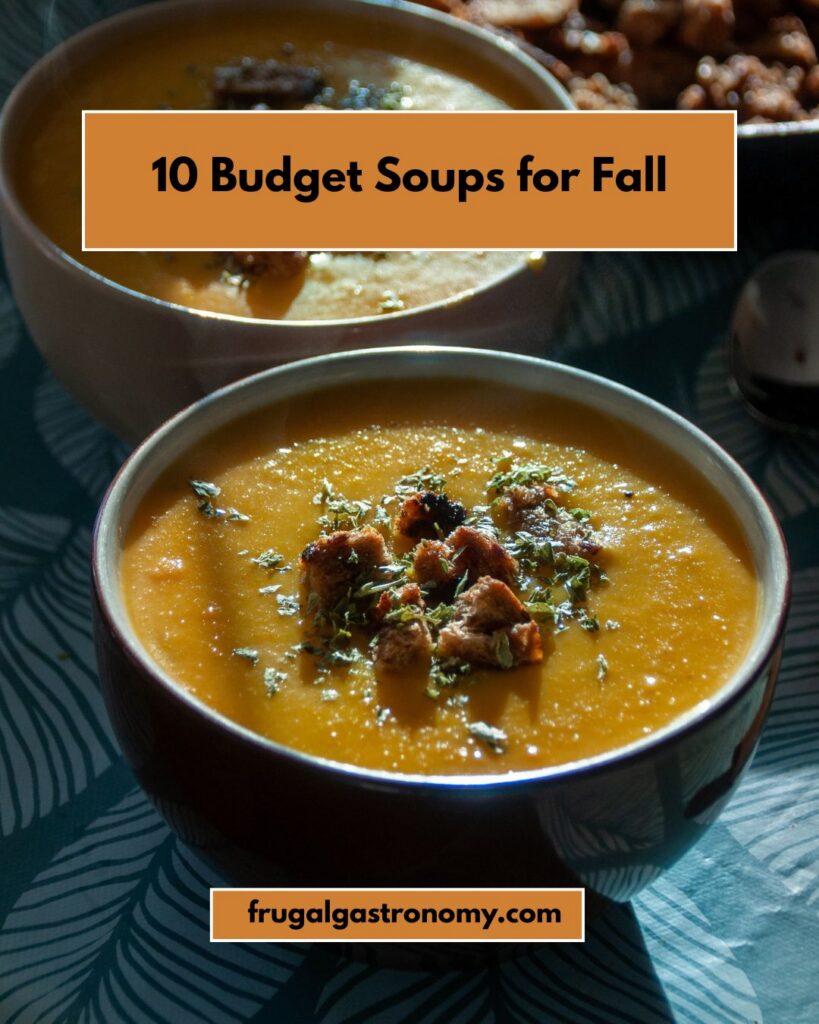 A bowl of what looks like pumpkin soup topped with croutons.