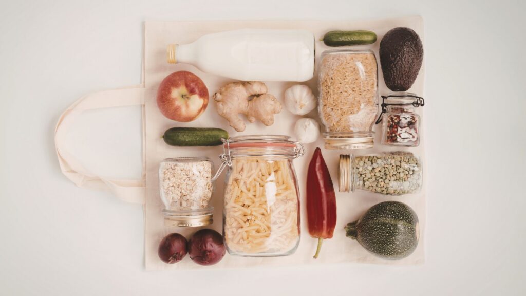 Flat lay shot of dry goods placed on top of a laid out grocery bag.