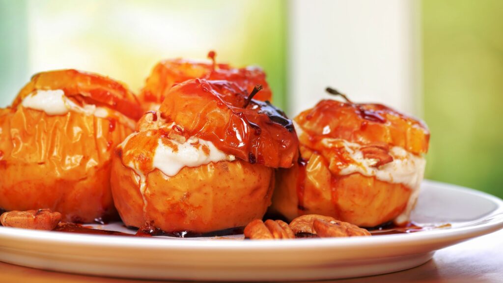 A plate of baked apples on a wooden table.