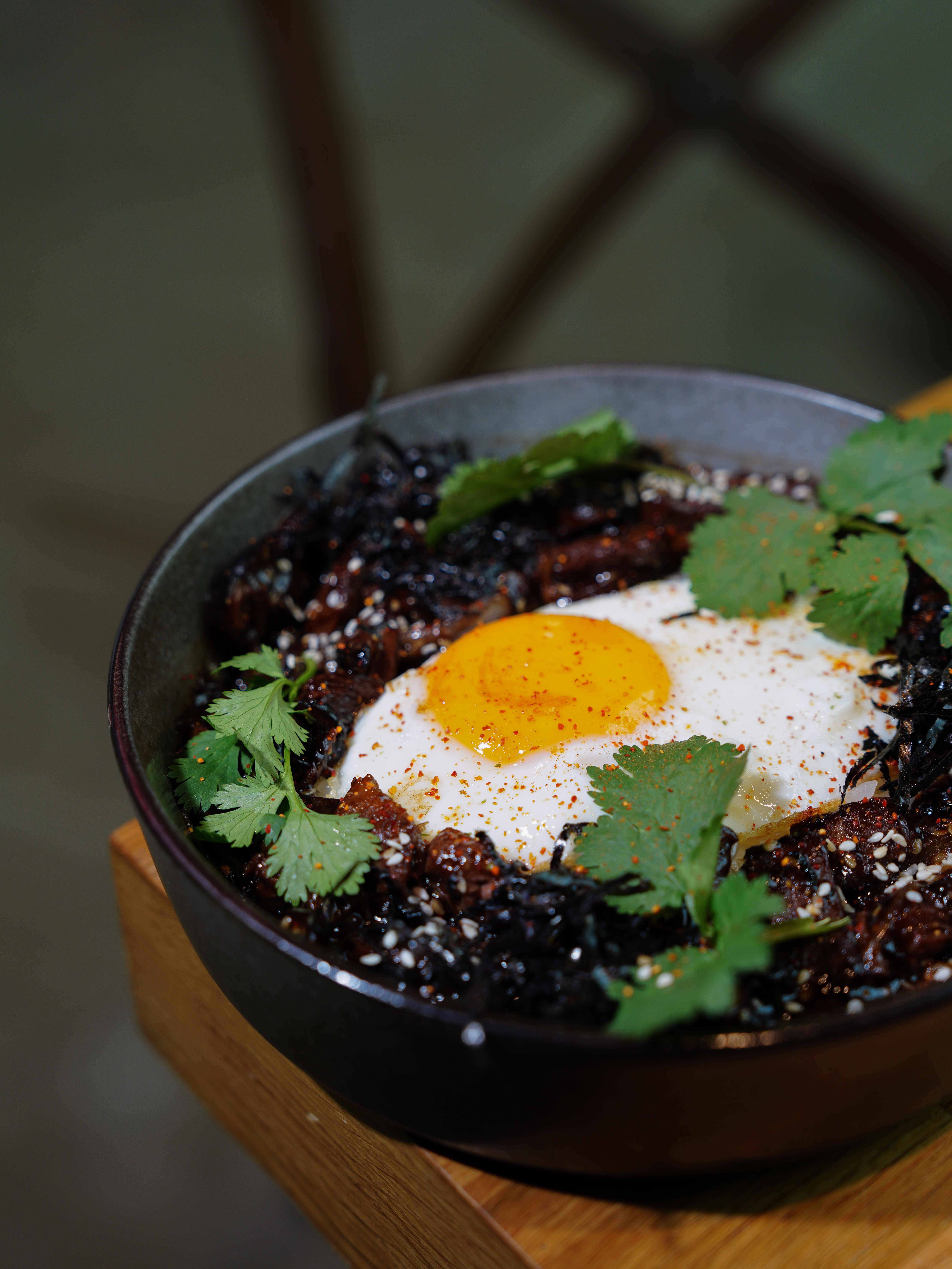 Savory bean and egg breakfast bowl with black beans, a fried egg and fresh cilantro