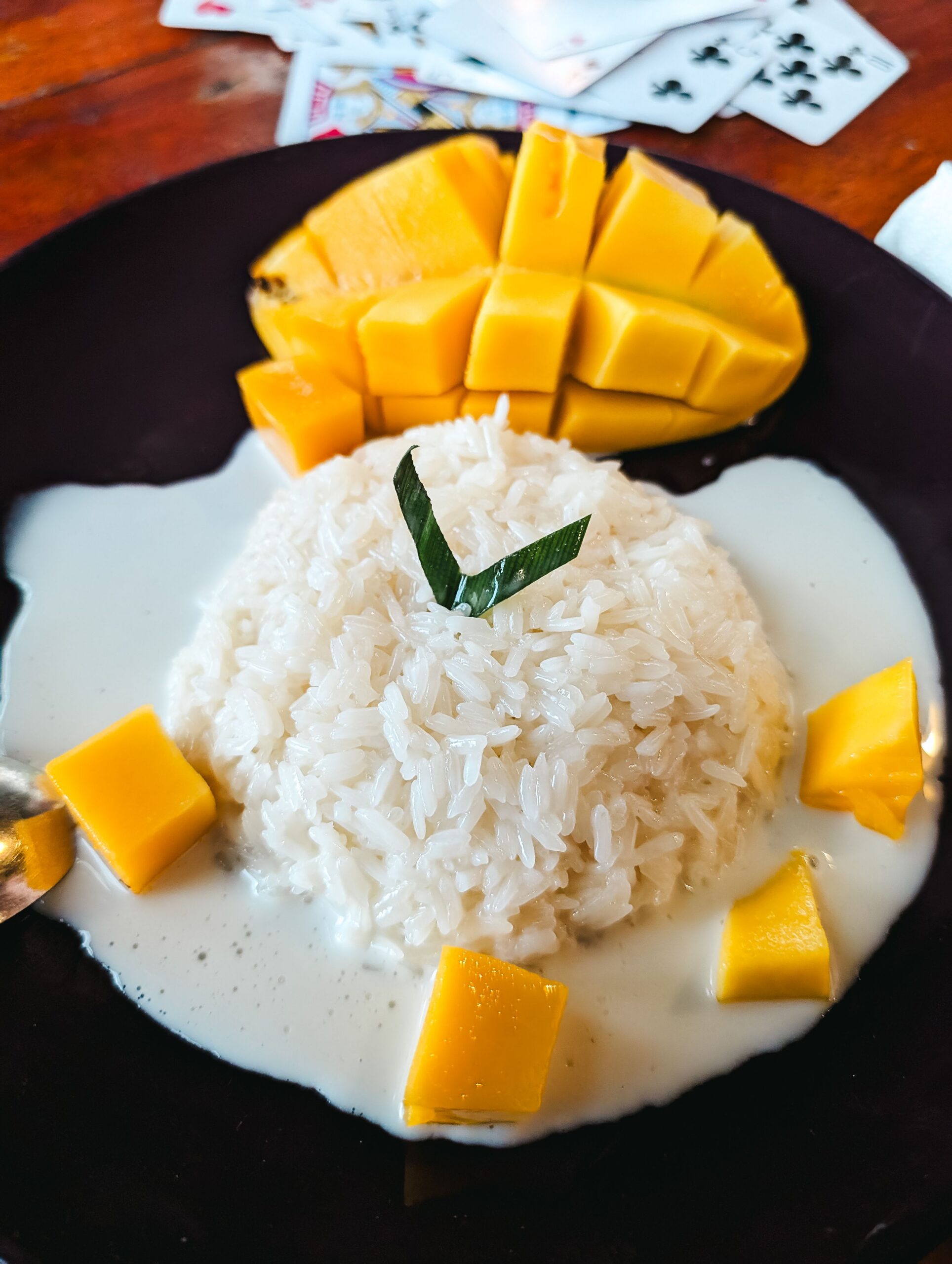 Delicious Thai dessert featuring ripe mango and sticky rice topped with coconut sauce.