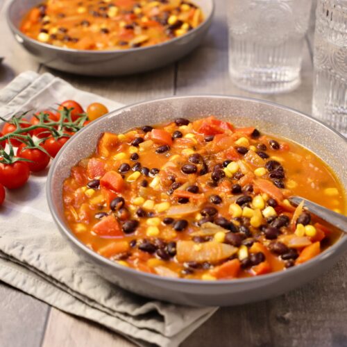 Warm and hearty vegetable bean stew served in rustic bowls, perfect for a cozy meal.