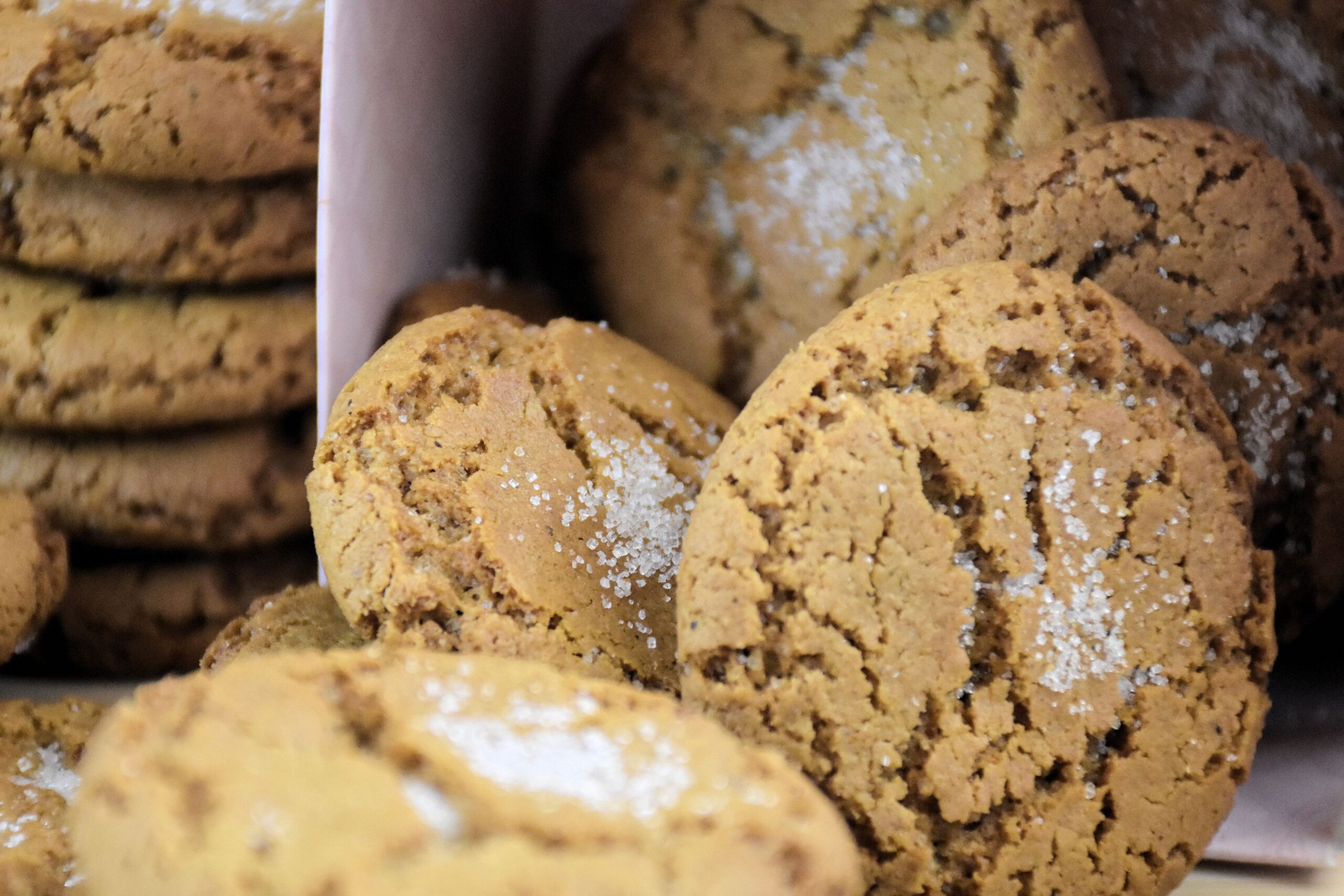 Soft spiced cookies sprinkled with sugar, stacked on a board.