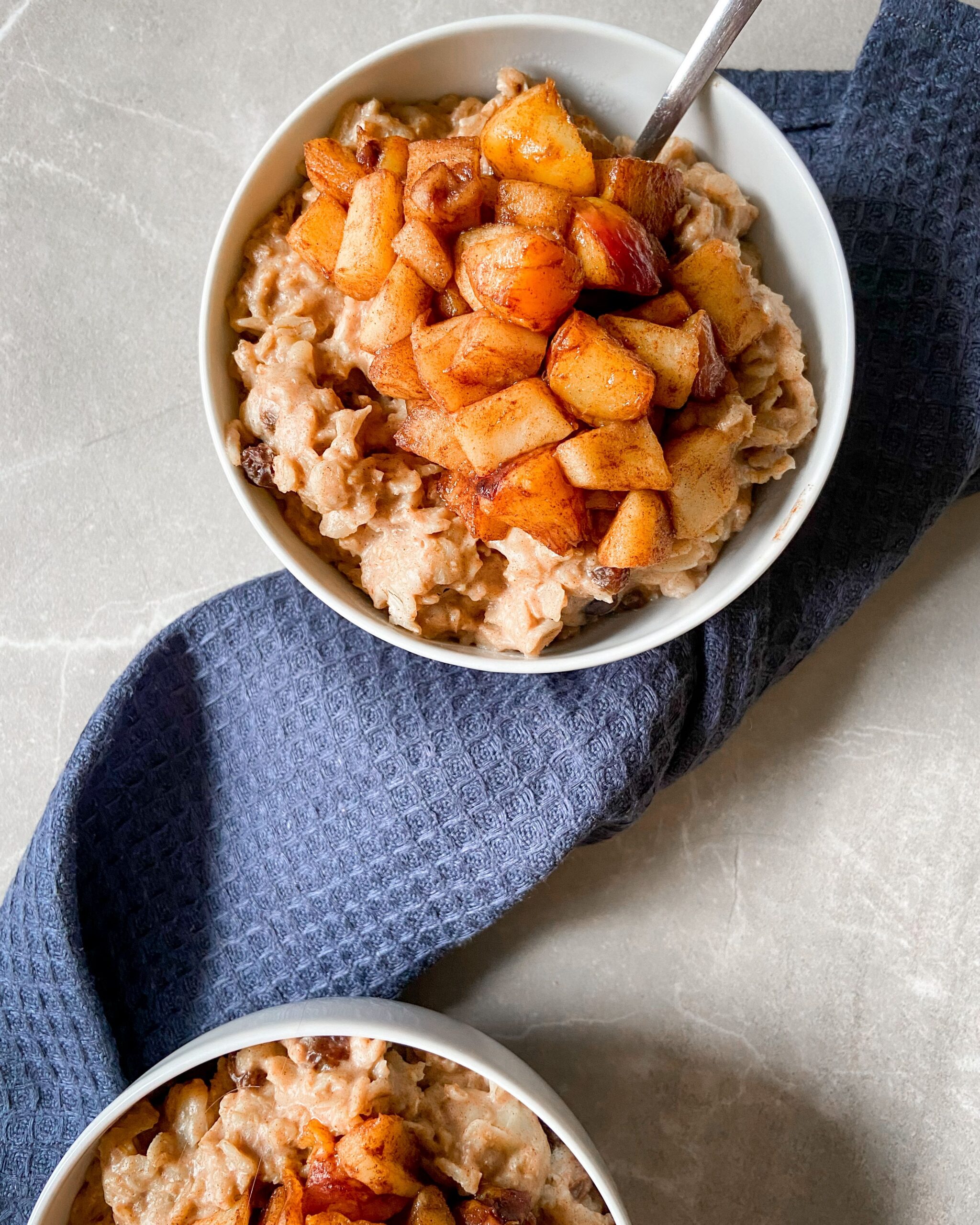 Bowl of creamy oatmeal topped with cinnamon-cooked apple pieces