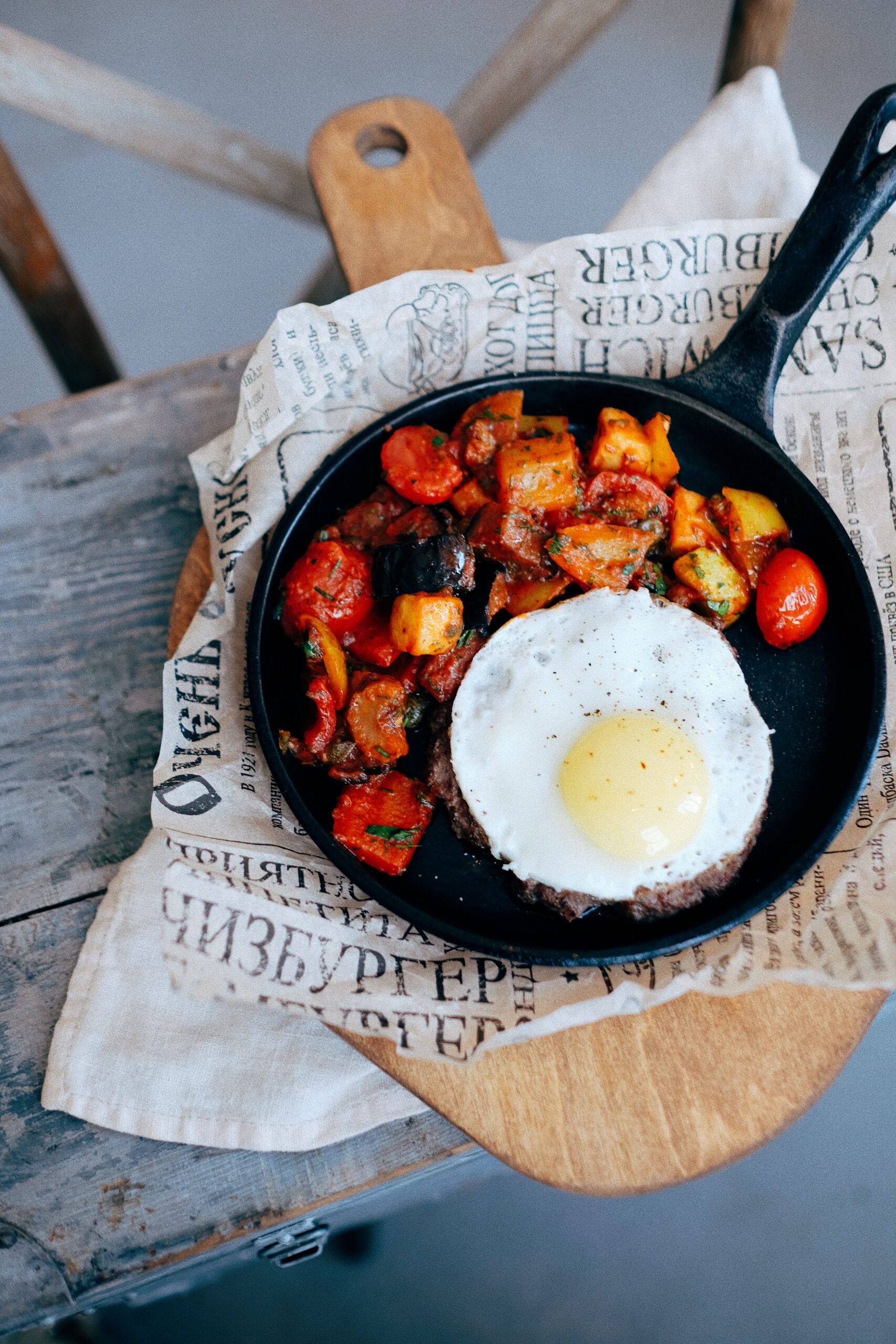 Cast iron skillet of crisp potato hash with a fried egg on top