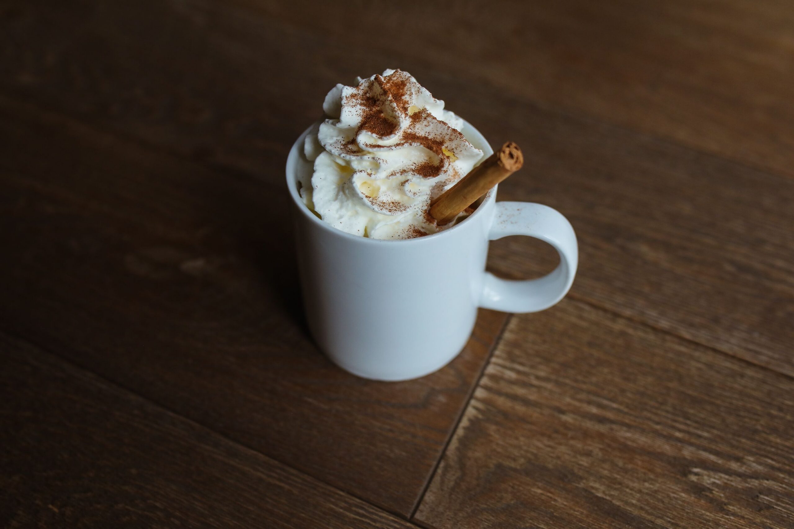 Homemade pumpkin spice latte in a white mug topped with whipped cream and cinnamon