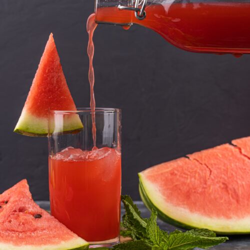 Watermelon punch poured into a glass, garnished with mint and fresh watermelon slices
