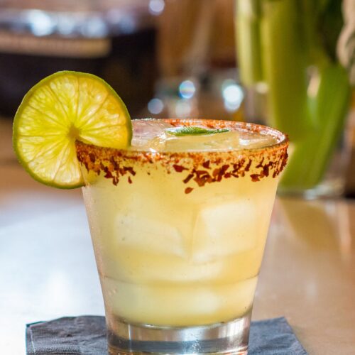 Mango margarita over ice with a chili-lime salt rim and a lime wheel