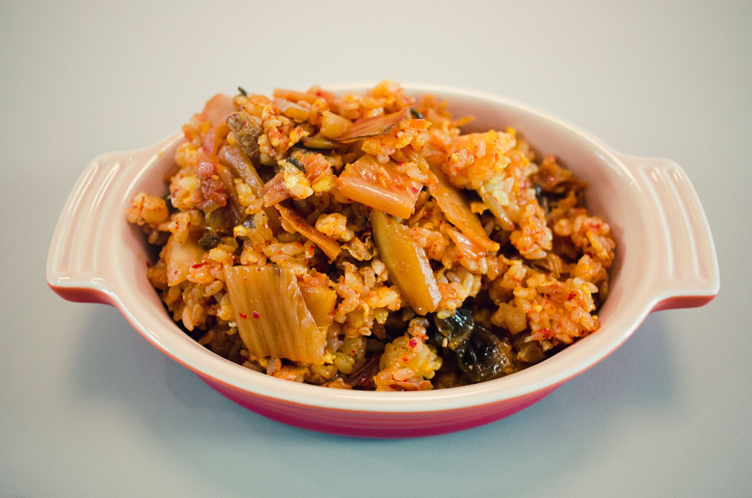Tantalizing Korean Kimchi Fried Rice served in a ceramic bowl, showcasing vibrant colors and textures.