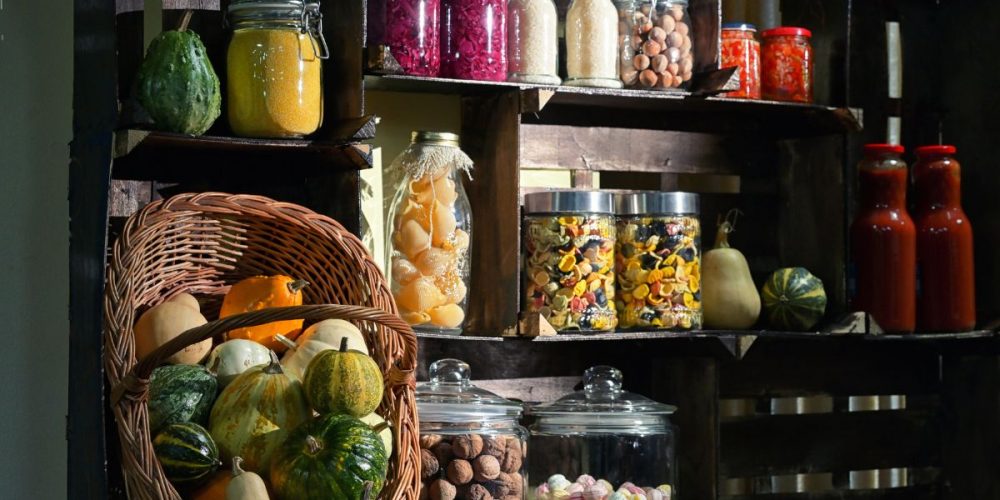 A pantry with dark shelves stocked with fall produce.