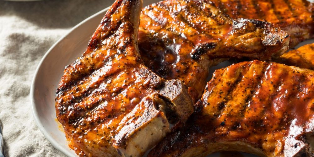A plate of girlled pork chops. This article talks about The Cheapest Cuts of Pork.