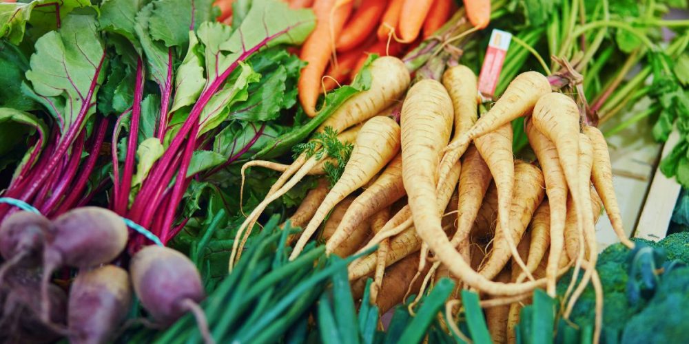Closeup shot of root vegetables such as carrots, parsnips, and beets.