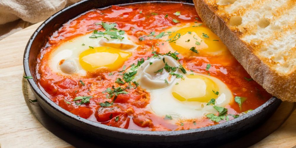A plate of shakshuka with toasted sourdough on the side. This recipe is one of the reasons why You’ll Love This Weekly Meal Plan for a Family of 4 for $150.