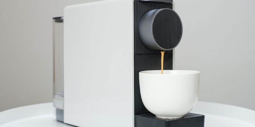 Coffee dripping down a white coffee cup from a K-cup Coffee Machine.