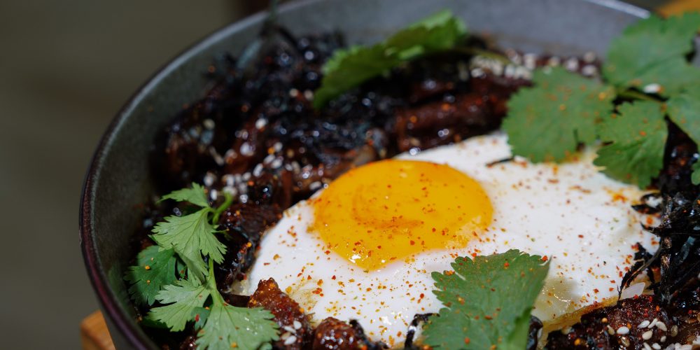 Savory bean and egg breakfast bowl with black beans, a fried egg and fresh cilantro