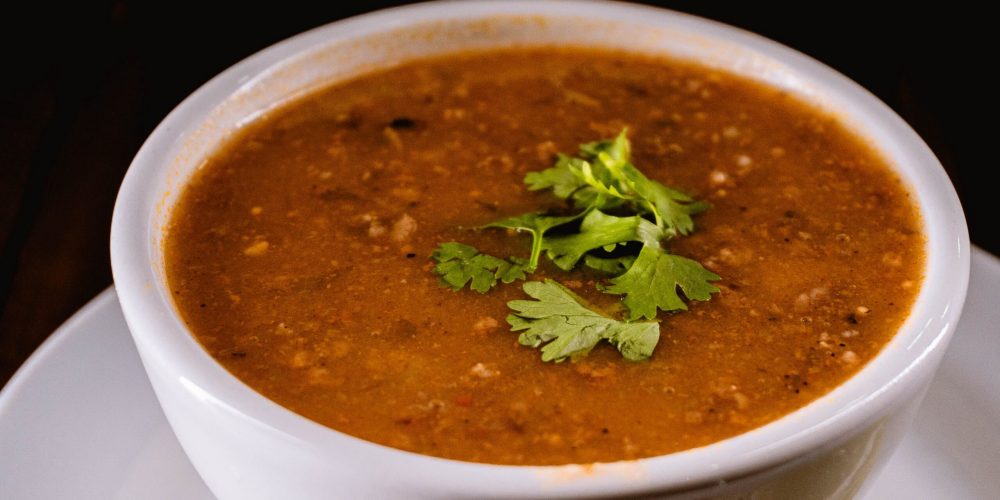 A warm bowl of lentil soup garnished with fresh cilantro.