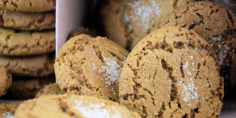 Soft spiced cookies sprinkled with sugar, stacked on a board.