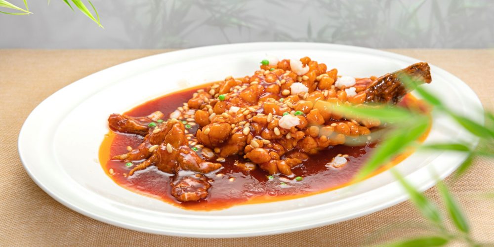Mouthwatering Kung Pao Chicken garnished with sesame seeds and sauce, offering a flavorful dining experience.