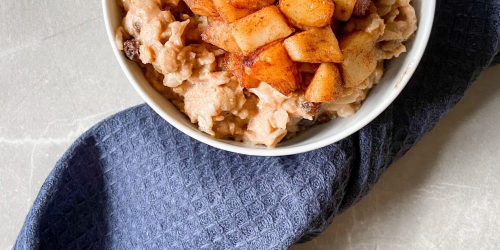 Bowl of creamy oatmeal topped with cinnamon-cooked apple pieces