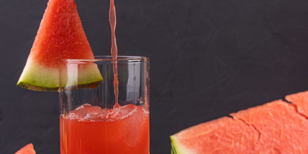 Watermelon punch poured into a glass, garnished with mint and fresh watermelon slices