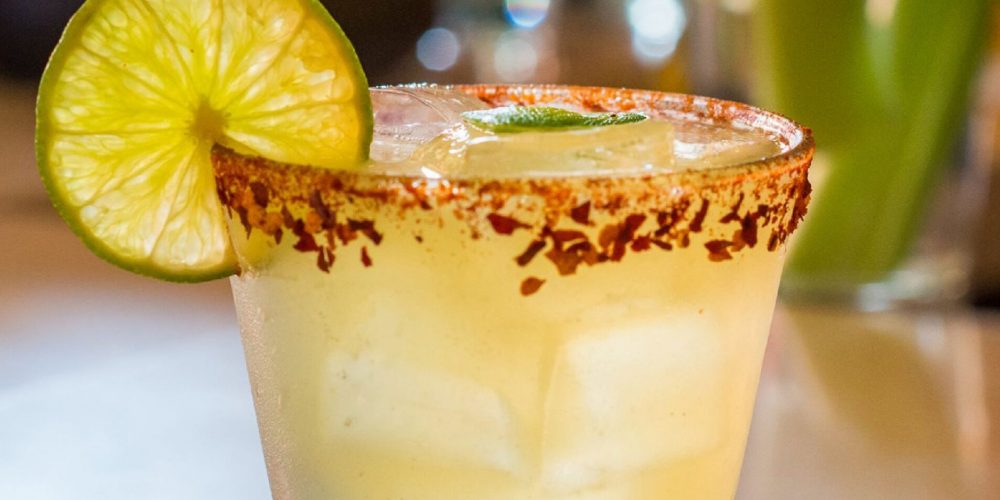 Mango margarita over ice with a chili-lime salt rim and a lime wheel