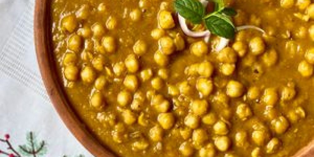 A close-up of traditional Indian chana masala garnished with fresh herbs, showcasing its rich and appetizing flavors.